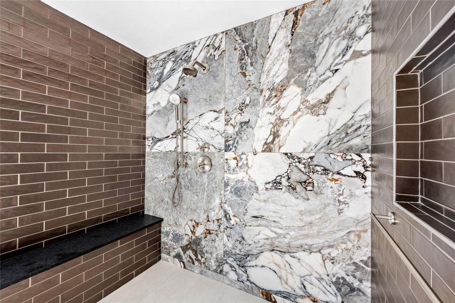 Bathroom with a marble finish shower, tile walls, and tile patterned flooring