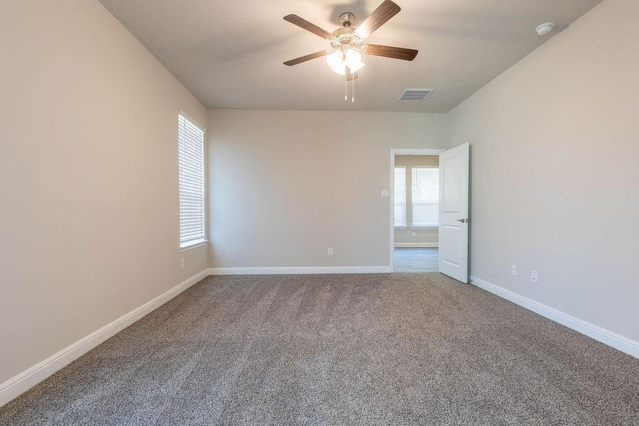 Carpeted spare room with healthy amount of natural light and ceiling fan Carpeted spare room with healthy amount of natural light and ceiling fan