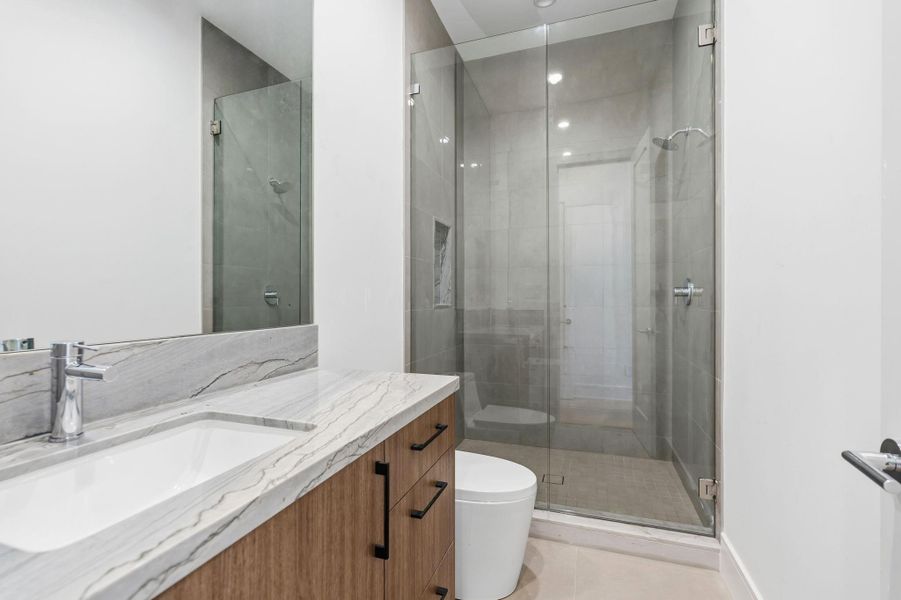 Guest bathrooms with Grohe fixtures and White Maldives natural stone countertops.