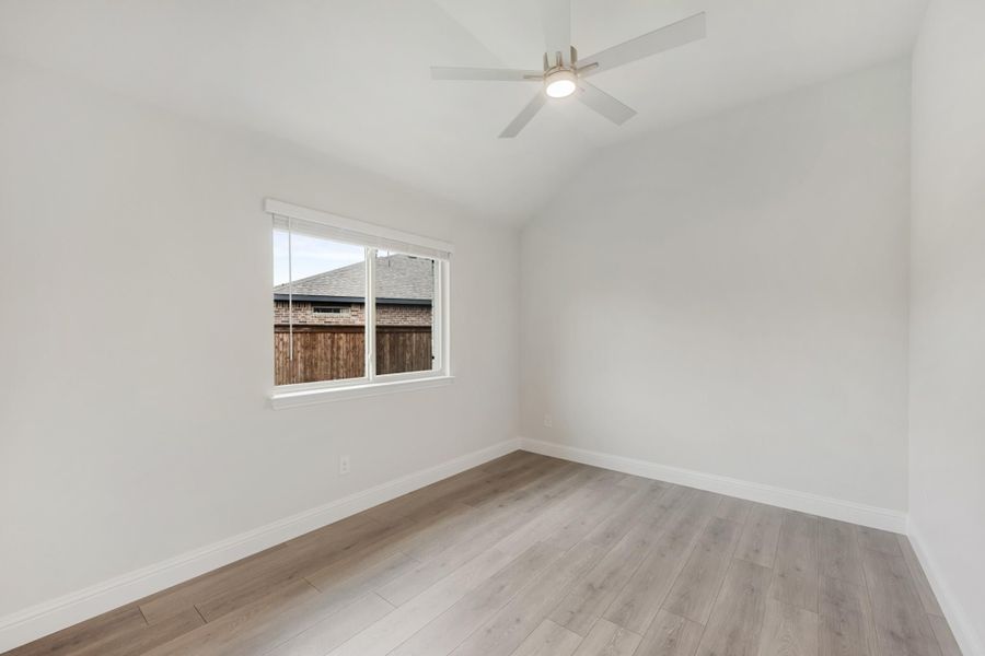 Empty bedroom with light wood floors, white walls, ceiling fan, and single window Empty bedroom with light wood floors, white walls, ceiling fan, and single window