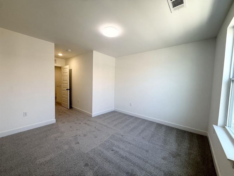 Unfurnished room featuring dark carpet and baseboards