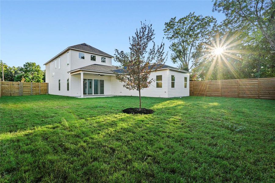 Rear view of property with ceiling fan, a patio area, a fenced backyard, and roof with shingles