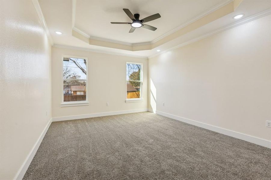 Carpeted empty room featuring a tray ceiling, crown molding, a ceiling fan, and recessed lighting