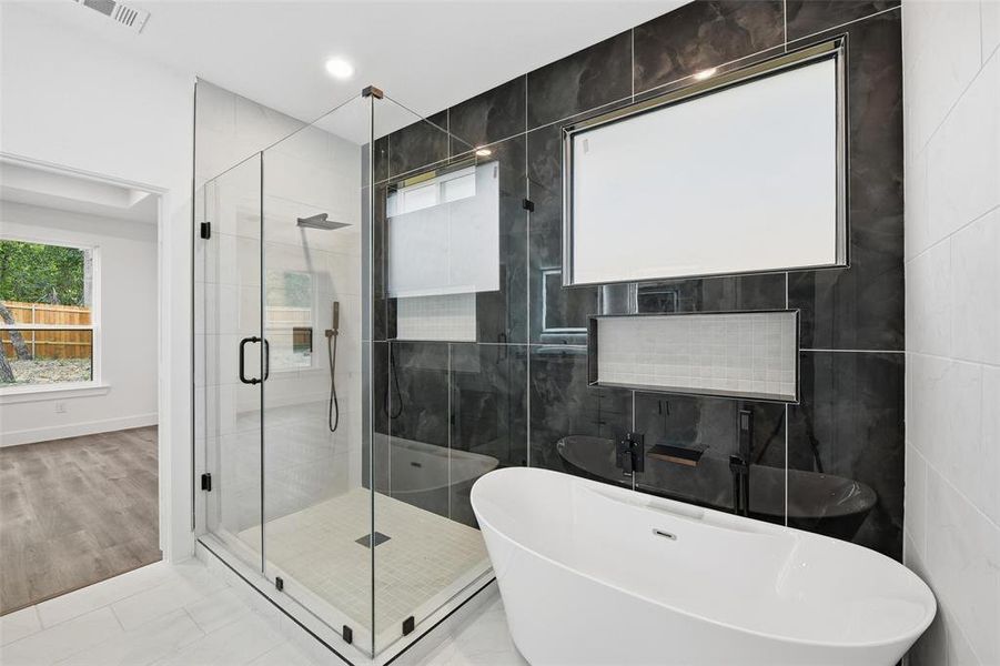 Full bathroom with a soaking tub, a stall shower, tile walls, tile patterned flooring, and recessed lighting