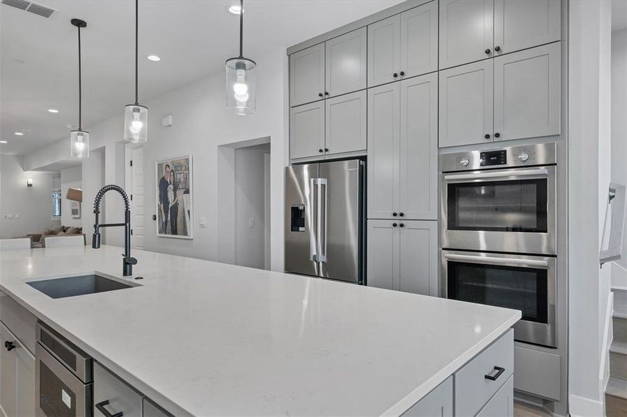 The open layout of the kitchen allows for seamless interaction with guests in the living and dining areas, ensuring you never miss a moment while entertaining