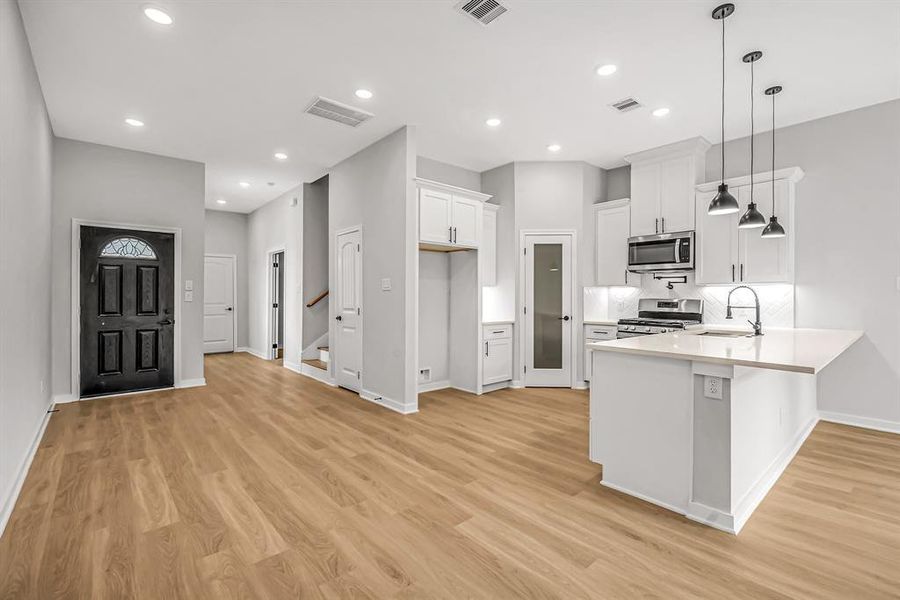 Kitchen features a corner walk in pantry, quartz countertops, under counter lighting and pot filler at the stove.