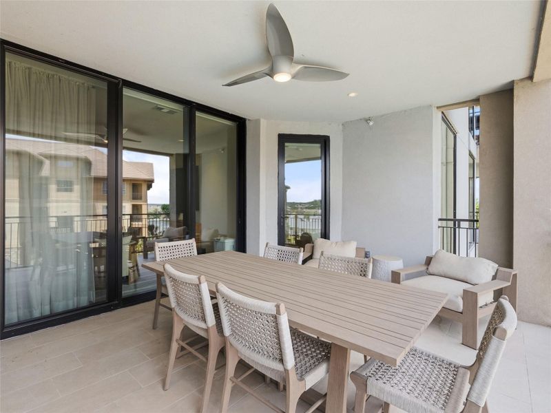 Spacious outdoor balcony featuring a ceiling fan with integrated lighting, recessed ceiling lighting, and light-toned tile flooring Spacious outdoor balcony featuring a ceiling fan with integrated lighting, recessed ceiling lighting, and light-toned tile flooring
