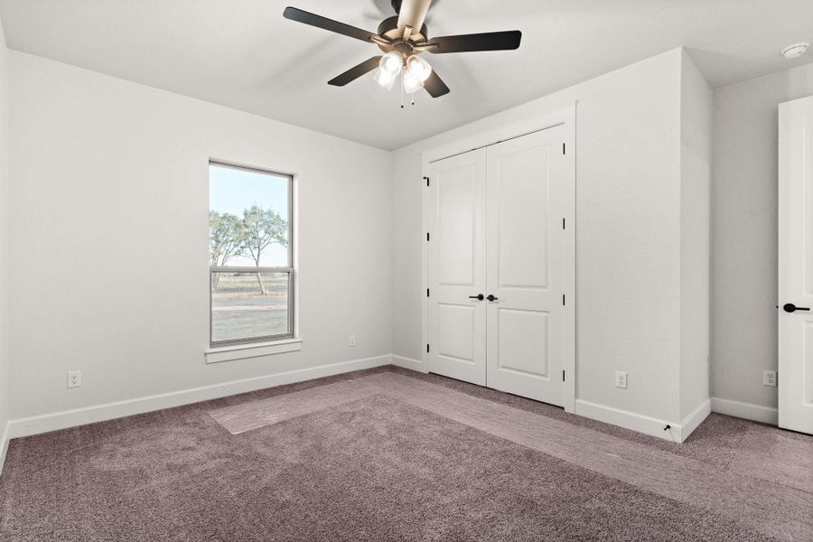 Unfurnished bedroom featuring carpet, ceiling fan, and a closet Unfurnished bedroom featuring carpet, ceiling fan, and a closet