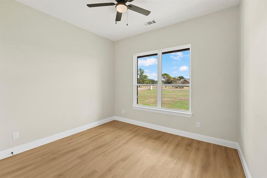 Unfurnished room featuring light wood-type flooring and a ceiling fan