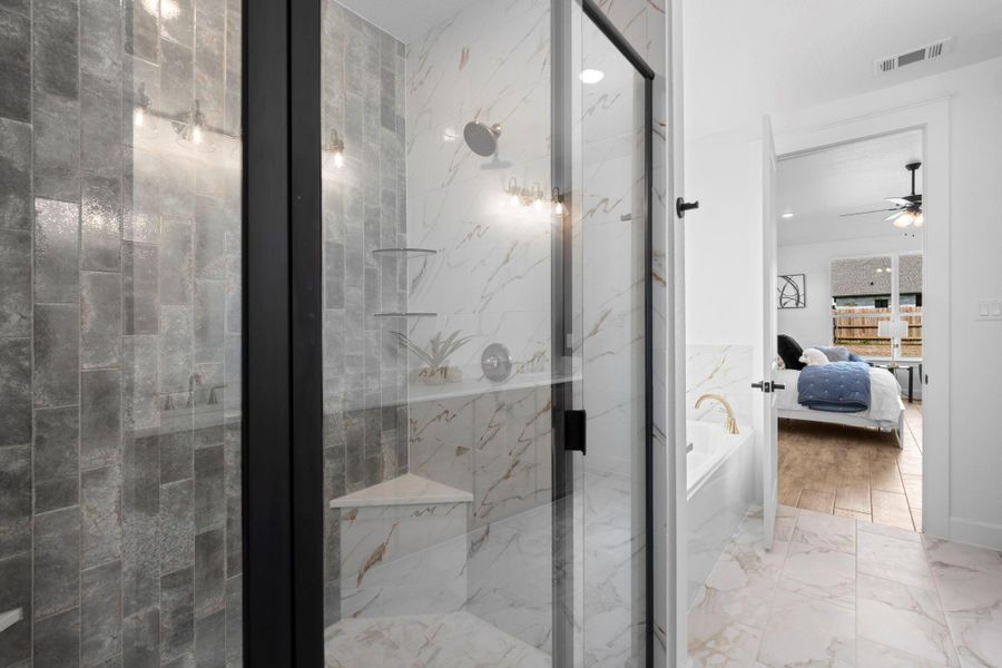 Ensuite bathroom featuring light marble finish floors, a tub, a marble finish shower, and a ceiling fan