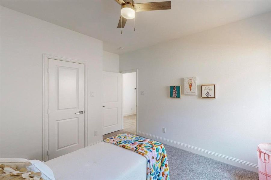 Carpeted bedroom with ceiling fan