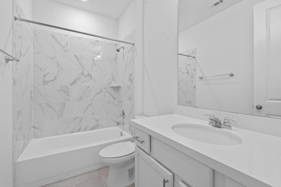 Bathroom featuring vanity, tub / shower combination, and toilet