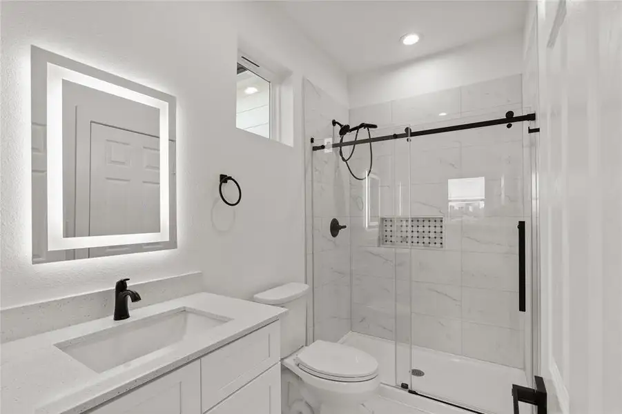 Full bathroom with vanity, a stall shower, and a textured wall