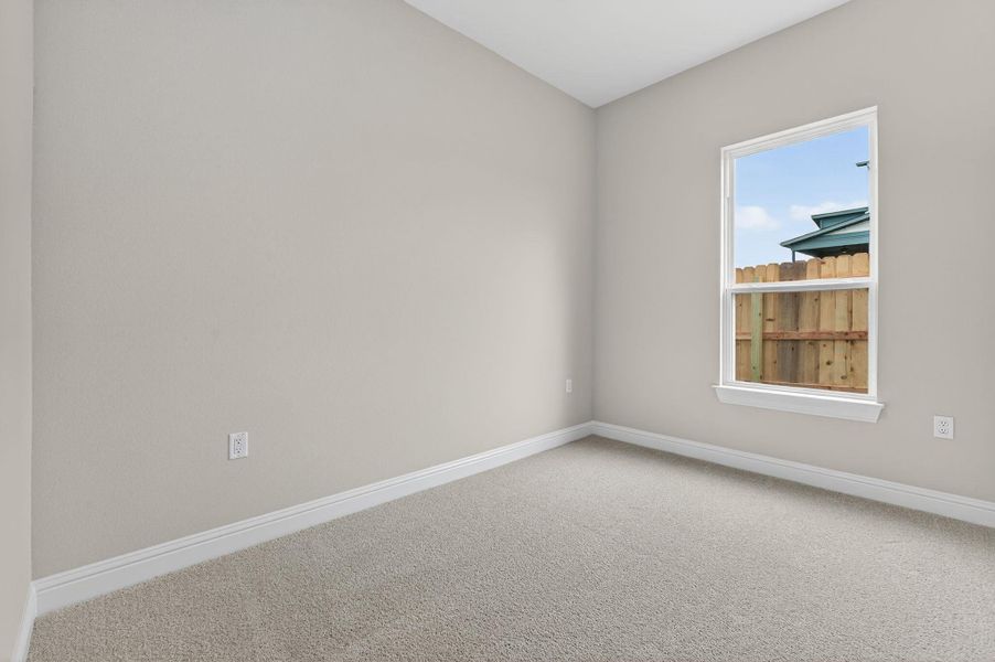 Carpeted empty room featuring baseboards