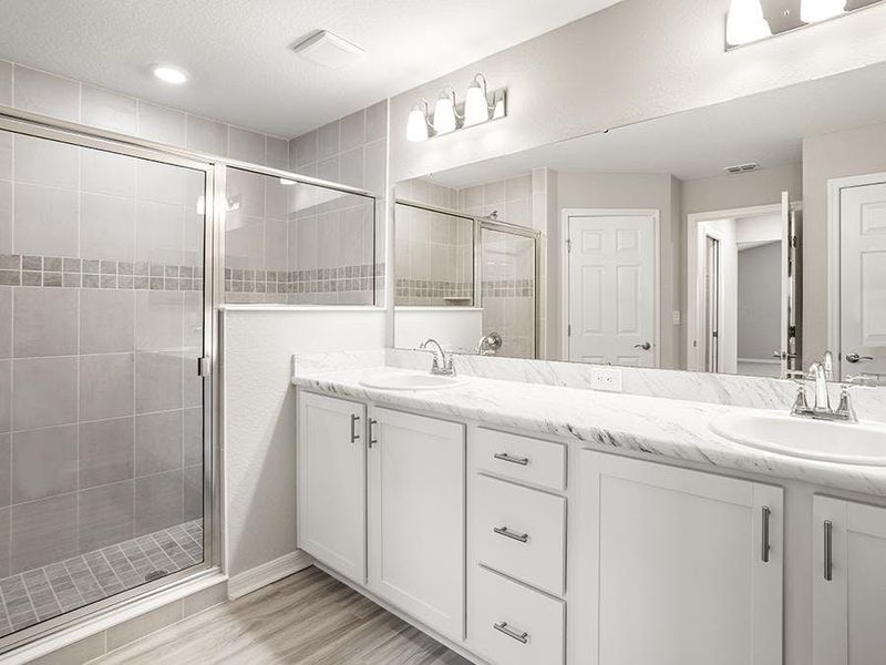 The en-suite owner`s bath includes a large tiled shower, linen closet, and closeted toilet - Sophia by Highland Homes