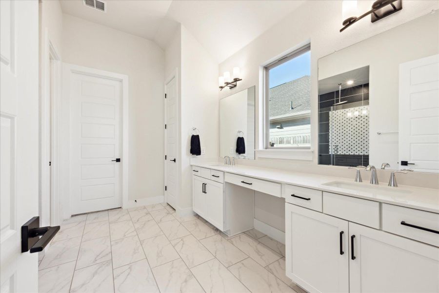 Spacious primary Bathroom with marble finish floor, double vanity sink, oversized shower and walk-in closet