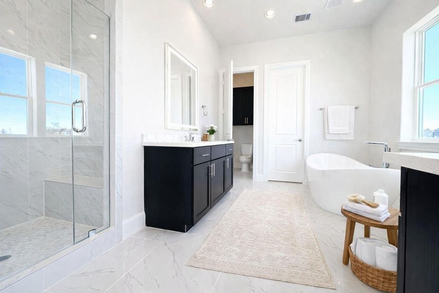 The naturally lit primary bathroom has separate shower and soaking tub. Virtual staging added.