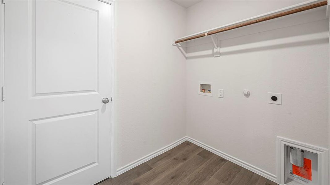 Utility space featuring light wood-finish flooring, white baseboards, and a white interior door with a chrome knob