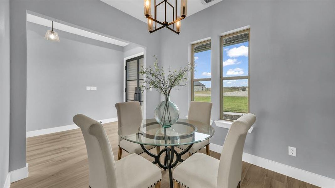 Dining area with wood finished floors and a chandelier