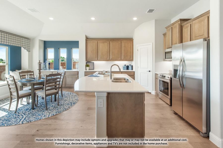 Kitchen with center island, stainless steel appliances, wood cabinets, and open dining area with hardwood floors Kitchen with center island, stainless steel appliances, wood cabinets, and open dining area with hardwood floors