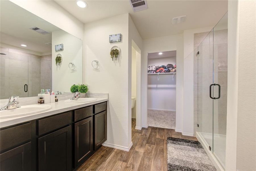 Primary Bathroom with Shower and Double vanity. Toilet is in the covered space