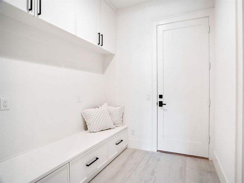 Mudroom featuring light wood-style floors and baseboards