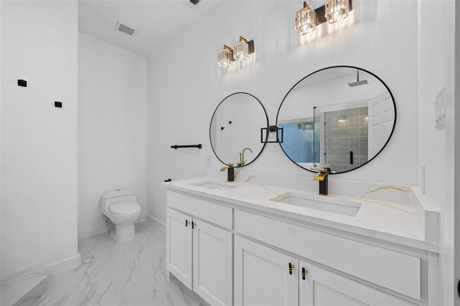 Full bathroom with a stall shower, double vanity, and light marble finish floors Full bathroom with a stall shower, double vanity, and light marble finish floors