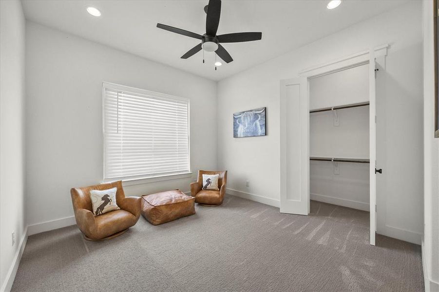 Sitting room featuring ceiling fan and carpet floors