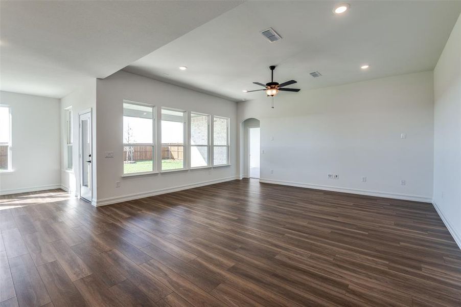 Empty room featuring ceiling fan and dark hardwood / wood-style flooring