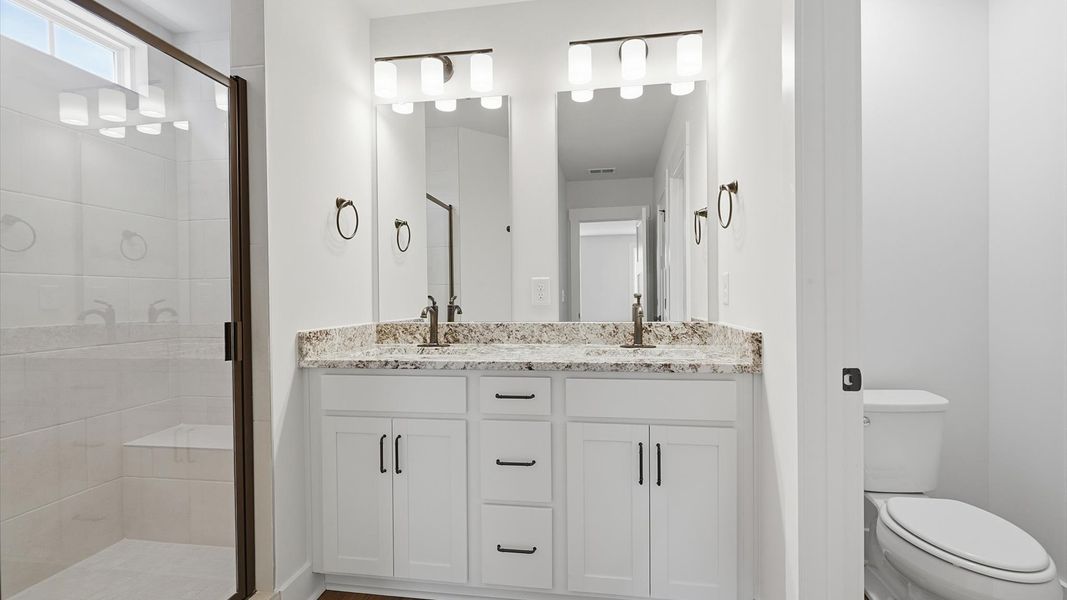 Superior en-suite primary bathroom with stylish dual vanity and walk-in shower—crafted with high standards in mind Superior en-suite primary bathroom with stylish dual vanity and walk-in shower—crafted with high standards in mind