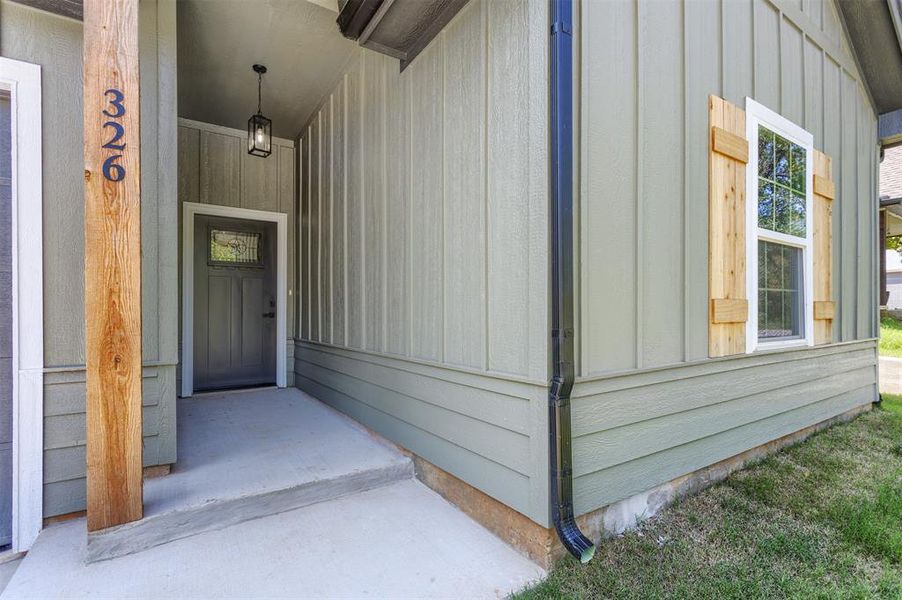 View of exterior entry featuring board and batten siding and a porch View of exterior entry featuring board and batten siding and a porch