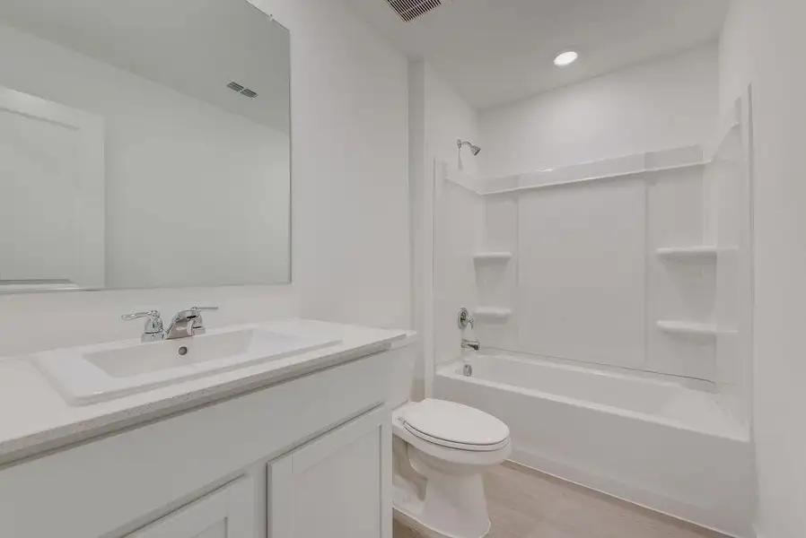 Bathroom with shower / bath combination, vanity, and light wood-style flooring
