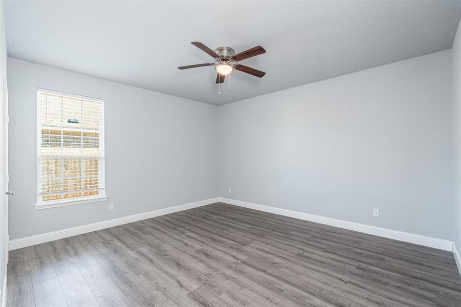 Empty room featuring a ceiling fan, baseboards, and wood finished floors