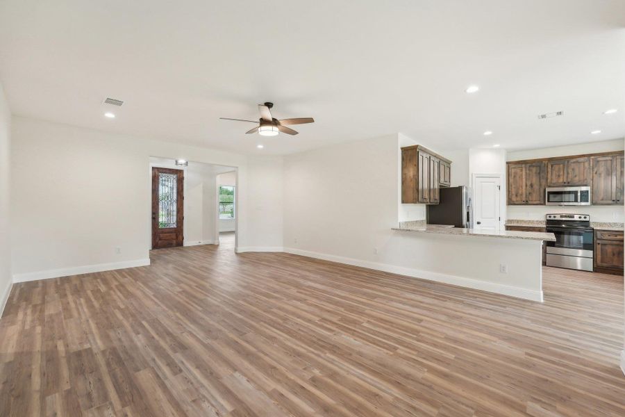 Living room with recessed lighting, Vinyl Wood Plank floor, visible vents, and a ceiling fan Living room with recessed lighting, Vinyl Wood Plank floor, visible vents, and a ceiling fan