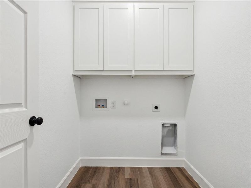 Washroom with hookup for a gas dryer, electric dryer hookup, dark hardwood / wood-style floors, hookup for a washing machine, and cabinets