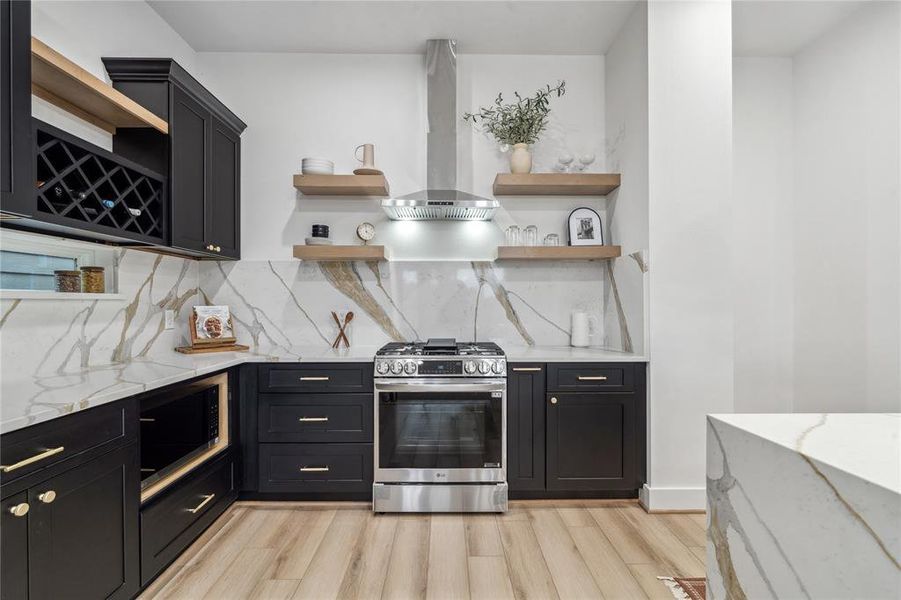 The heart of the home—featuring black cabinetry, a luxurious quartz backsplash, and floating wooden shelves that offer both style and function.