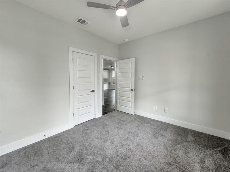 Unfurnished bedroom with carpet floors and a ceiling fan Unfurnished bedroom with carpet floors and a ceiling fan