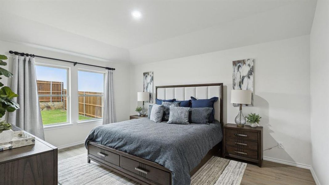 Bedroom with light wood-style flooring, recessed lighting, and vaulted ceiling Bedroom with light wood-style flooring, recessed lighting, and vaulted ceiling