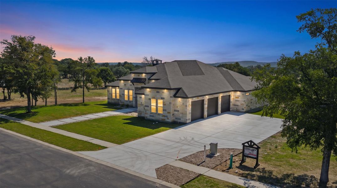 A striking modern residence boasts a multi-car garage, expansive driveway, and meticulously manicured lawns under an open sky. A striking modern residence boasts a multi-car garage, expansive driveway, and meticulously manicured lawns under an open sky.
