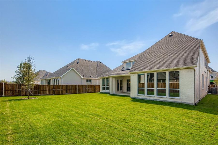 Rear view of house with a patio area, brick siding, and roof with shingles Rear view of house with a patio area, brick siding, and roof with shingles