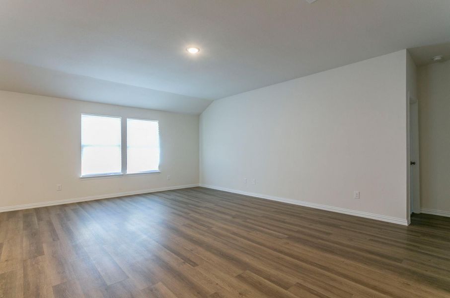Empty room with lofted ceiling, baseboards, recessed lighting, and dark wood-type flooring