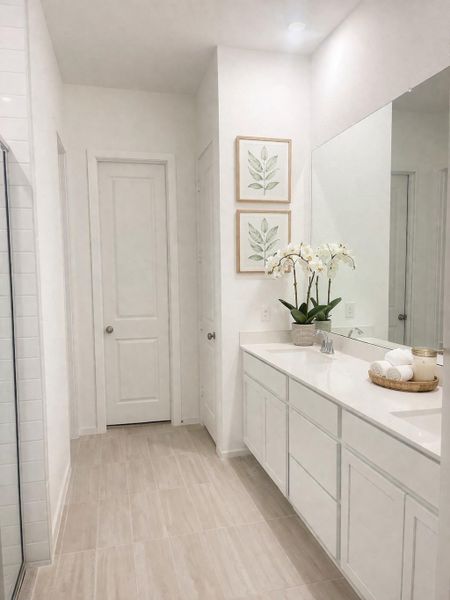 Master Bath with an oversized shower, tile floors, abundant amount of counterspace and cabinetry. Straight ahead is the huge walkin closet that is connected to the laundry room
