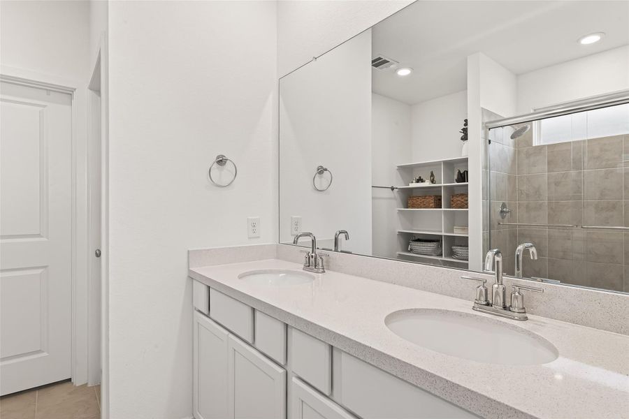 The primary bath offers a refined retreat designed for comfort and ease, featuring a well-appointed layout that enhances both functionality and style. The combination of a sleek glass-enclosed shower and spacious vanity area provides a relaxing setting for daily routines, making this bath a perfect extension of the tranquil primary suite.