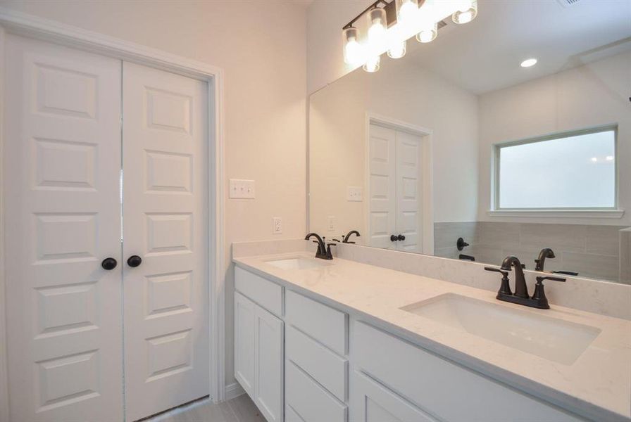 This elegant bathroom features a sleek dual vanity with chic lighting, offering ample counter space for convenience. The modern design and high-end finishes create a spa-like experience, perfect for starting and ending your day in luxury.