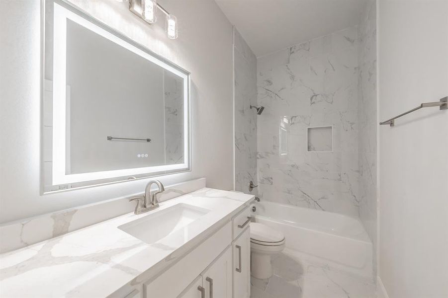 Bathroom with vanity, a combined bath / shower with marble appearance, and marble finish flooring