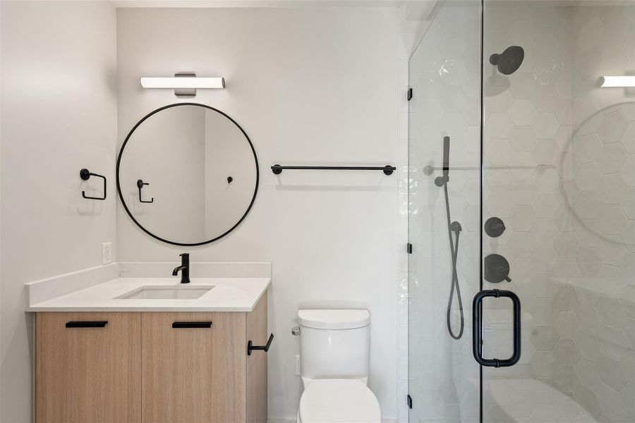 Full bath featuring toilet, a shower stall, and vanity