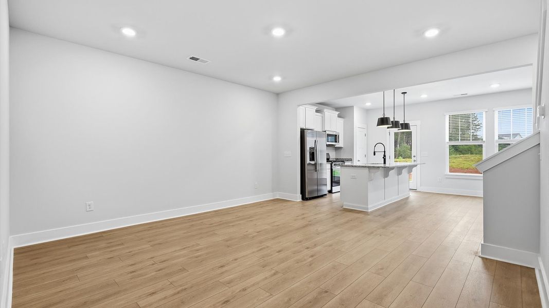 Hardwood flooring and high standards define this vibrant family room ideal for everyday living by DRB Homes Hardwood flooring and high standards define this vibrant family room ideal for everyday living by DRB Homes