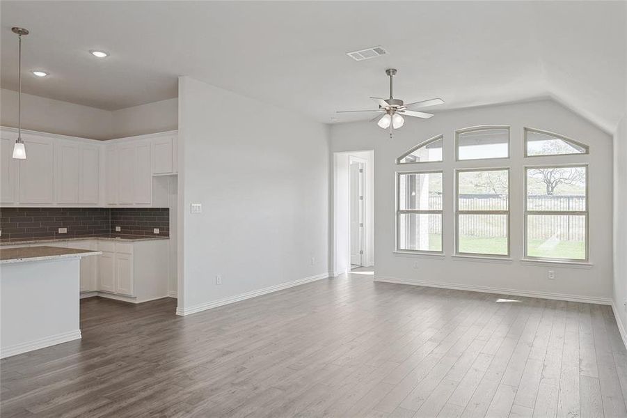 Unfurnished living room with wood-type flooring and ceiling fan