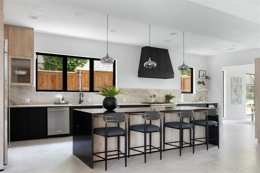 Kitchen featuring a healthy amount of sunlight, backsplash, dishwasher, and custom exhaust hood