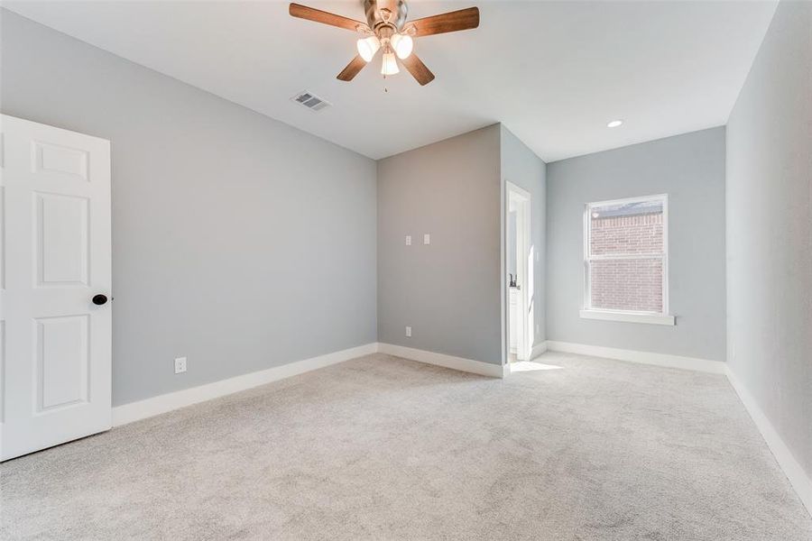 Empty room featuring light colored carpet and ceiling fan